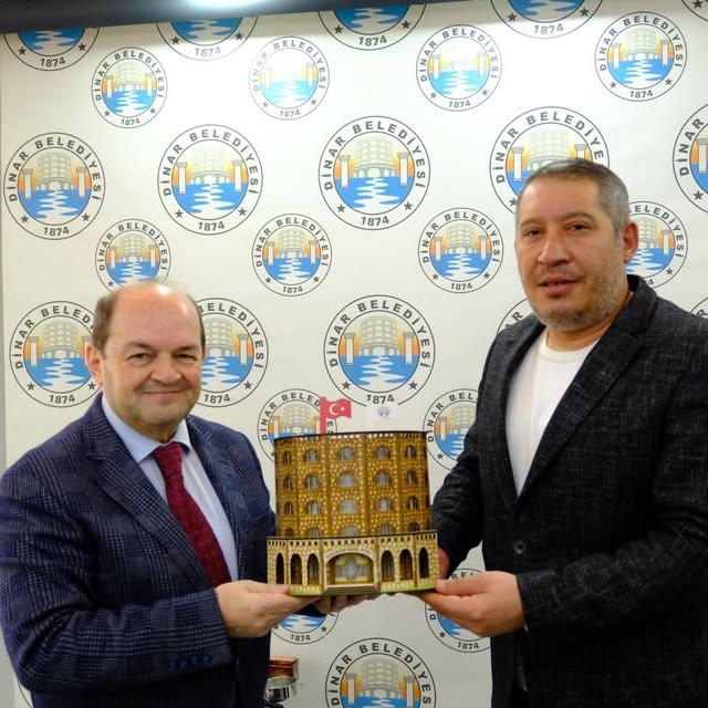 Dinar Belediye Başkanı Topçu, Gazeteci Güzbeyi İstiğe Takdim Etti
